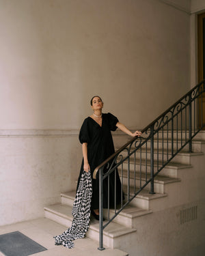 Girl on stairs wearing Black Organic Cotton Midi Dress with wide sleeves