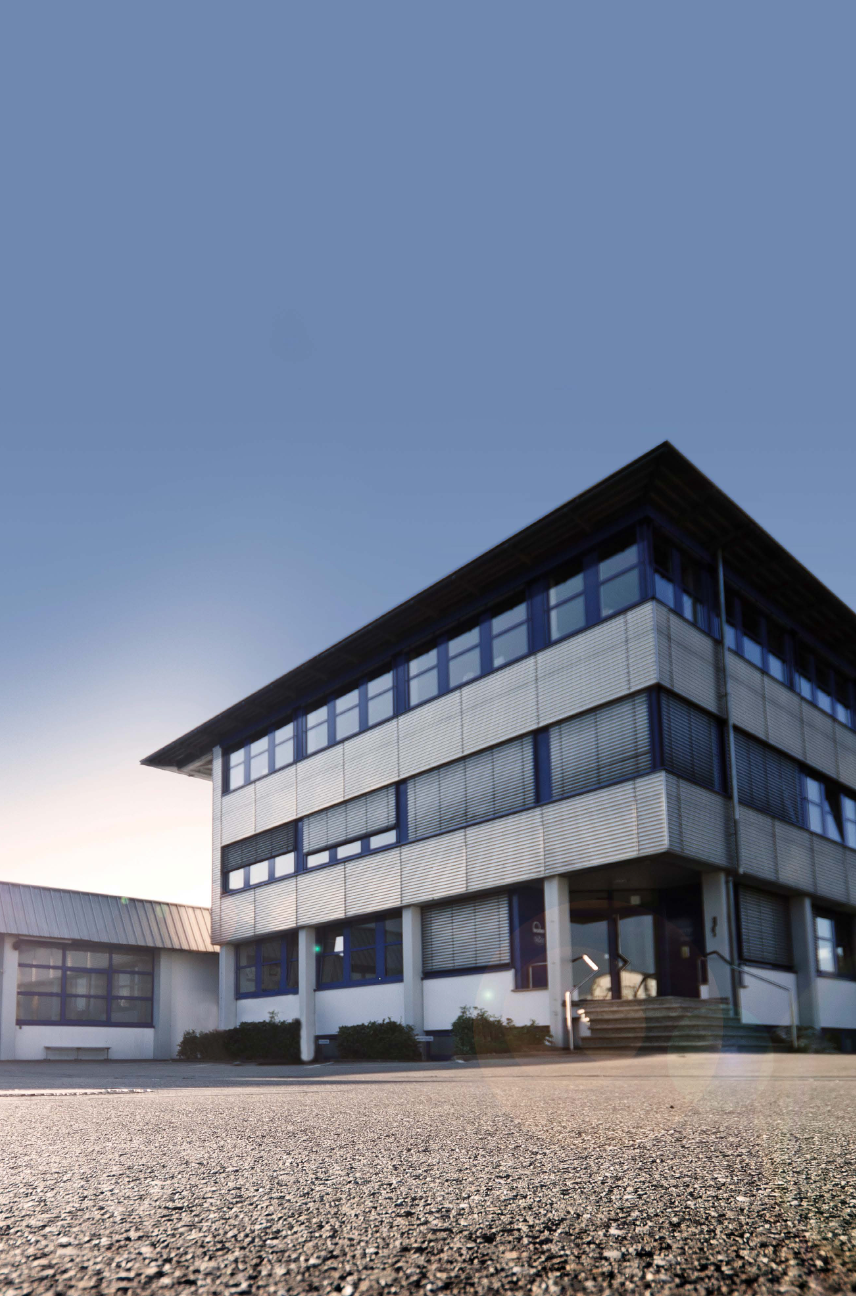 Headquater of our belt supplier in a modern, cubic design with a metal facade and dark blue windows.