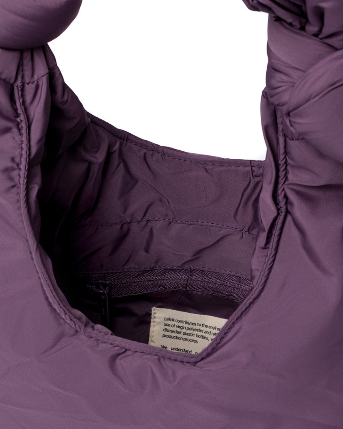 Close-up of the inside hood of the jan-n-june BAG BIWA PUFFY MINI PLUM jacket, highlighting quilted RPET fabric stitching and a sewn-in label.