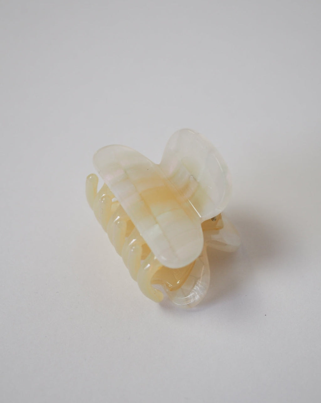 The jan-n-june MINI HEIRLOOM CLIP OPALITE SHELL CHECKER, a small pale yellow and white marbled acetate hair claw clip, is displayed on a plain white surface.