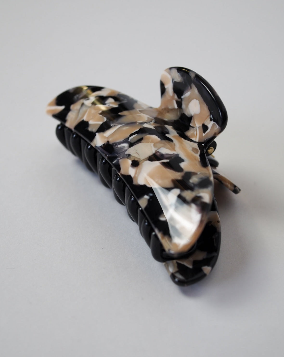 The jan-n-june MIDI HEIRLOOM CLAW ABALONE, a black and beige marbled hair clip made from Italian acetate with a curved, double-walled design, rests on a plain light gray surface.