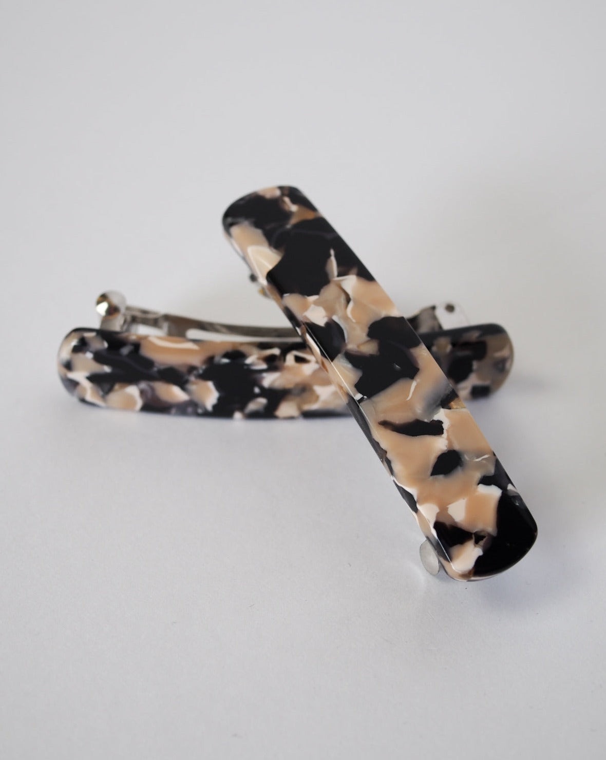 Two jan-n-june HEIRLOOM BARRETTE ABALONE hair clips, crafted from Italian acetate in a marbled black, beige, and cream design, are shown on a white background with one barrette resting atop the other.