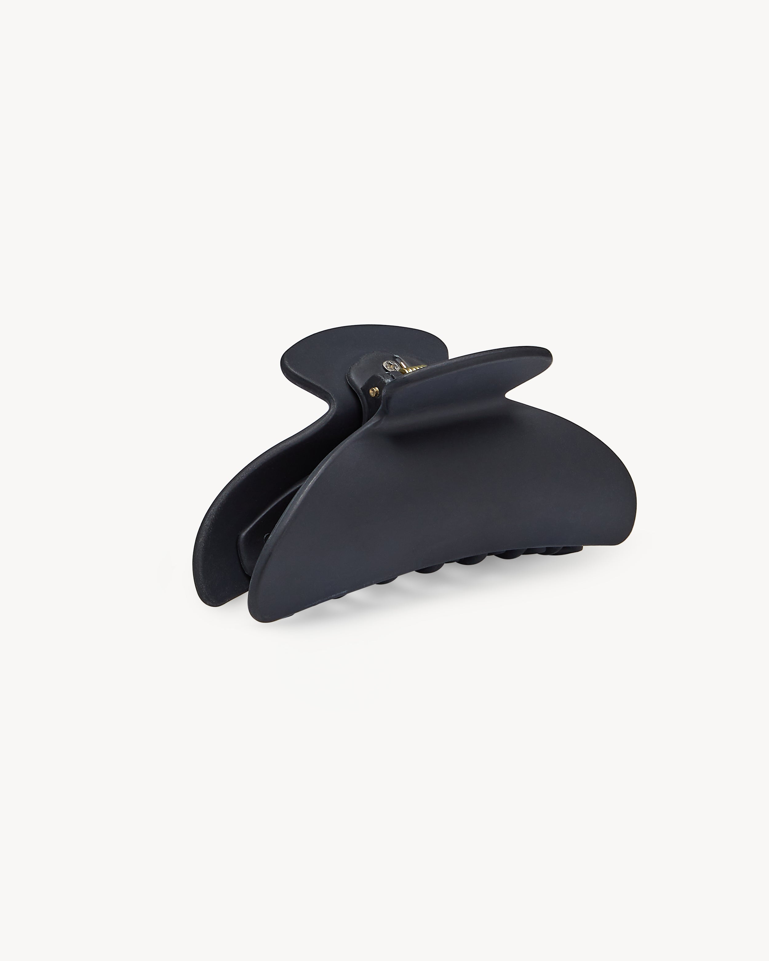 The jan-n-june MIDI HEIRLOOM CLAW BLACK MATTE is a curved, matte black hair clip with interlocking teeth, displayed on a plain white background—a sustainable and elegant accessory for daily styling.