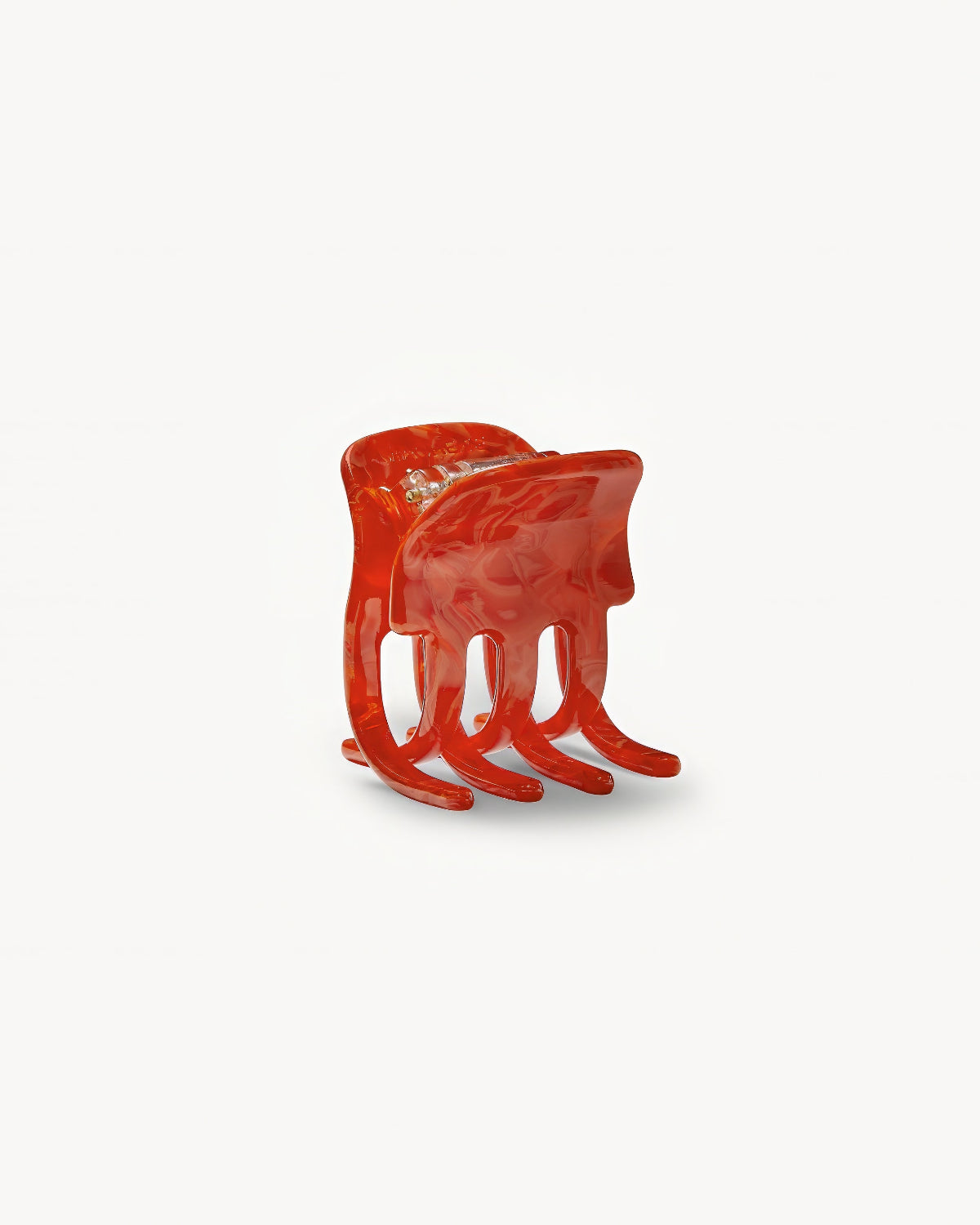 The MINI CLAW POPPY by jan-n-june is a glossy red sculptural chair with four curved legs and an abstract, fluid form, resembling a melted organic shape, showcased against a plain white background.