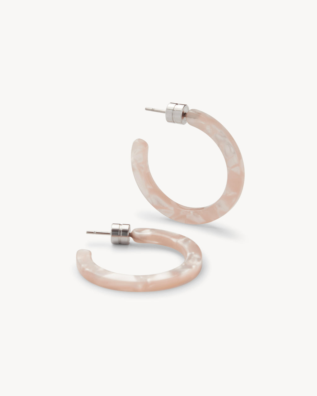 The jan-n-june MINI HOOPS PEACH SHELL are round, marbled light pink acetate mini hoop earrings with silver posts, shown on a white background.