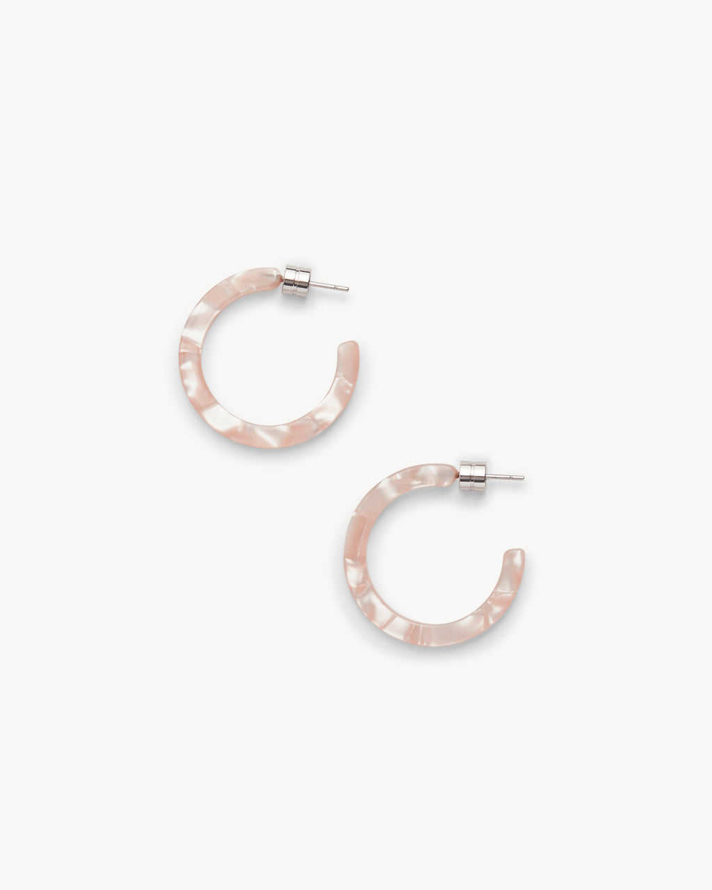 The jan-n-june MINI HOOPS PEACH SHELL are semi-translucent, pink marbled acetate mini hoop earrings with silver posts, shown on a white background.