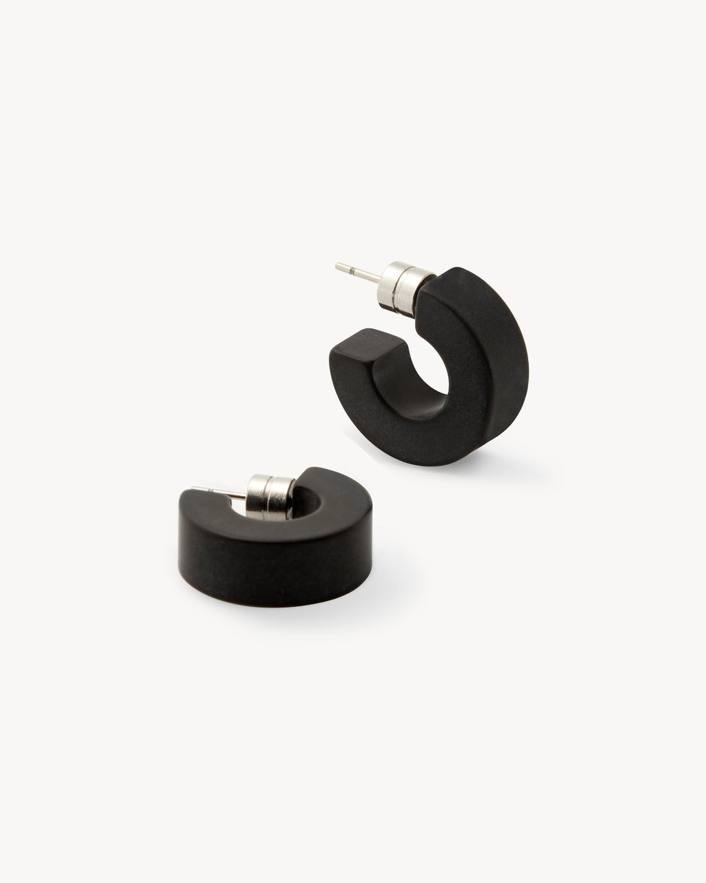 A pair of chunky, black matte MUSE HOOPS by jan-n-june with silver posts, displayed on a white background—sustainable earrings perfect for your everyday jewelry collection.