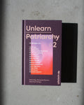 A purple hardcover book titled UNLEARN PATRIARCHY 2 by jan-n-june rests on a gray surface, featuring white and pink contributor names on the cover. The publisher is Ullstein, shown at the bottom right.