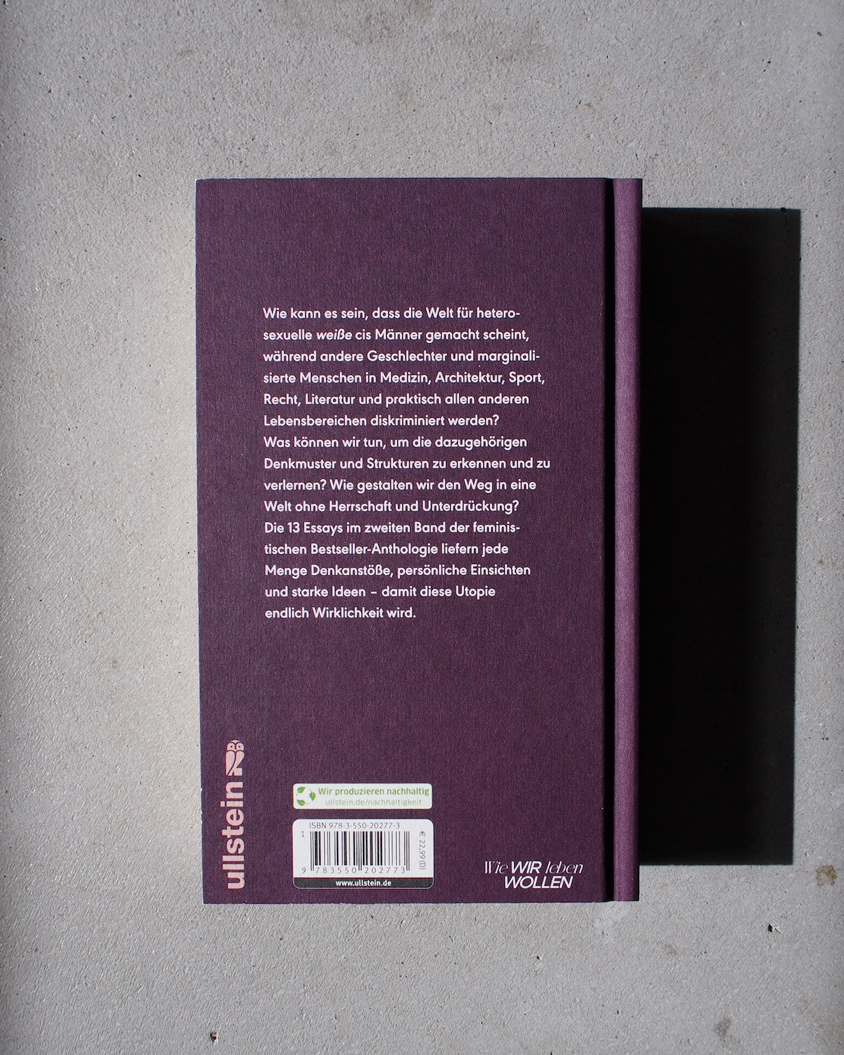 A purple hardcover book titled UNLEARN PATRIARCHY 2 by jan-n-june rests face down on a light gray surface. The back cover shows German text, a bottom barcode, and the publishers logo ullstein to the left of this feminist anthology.