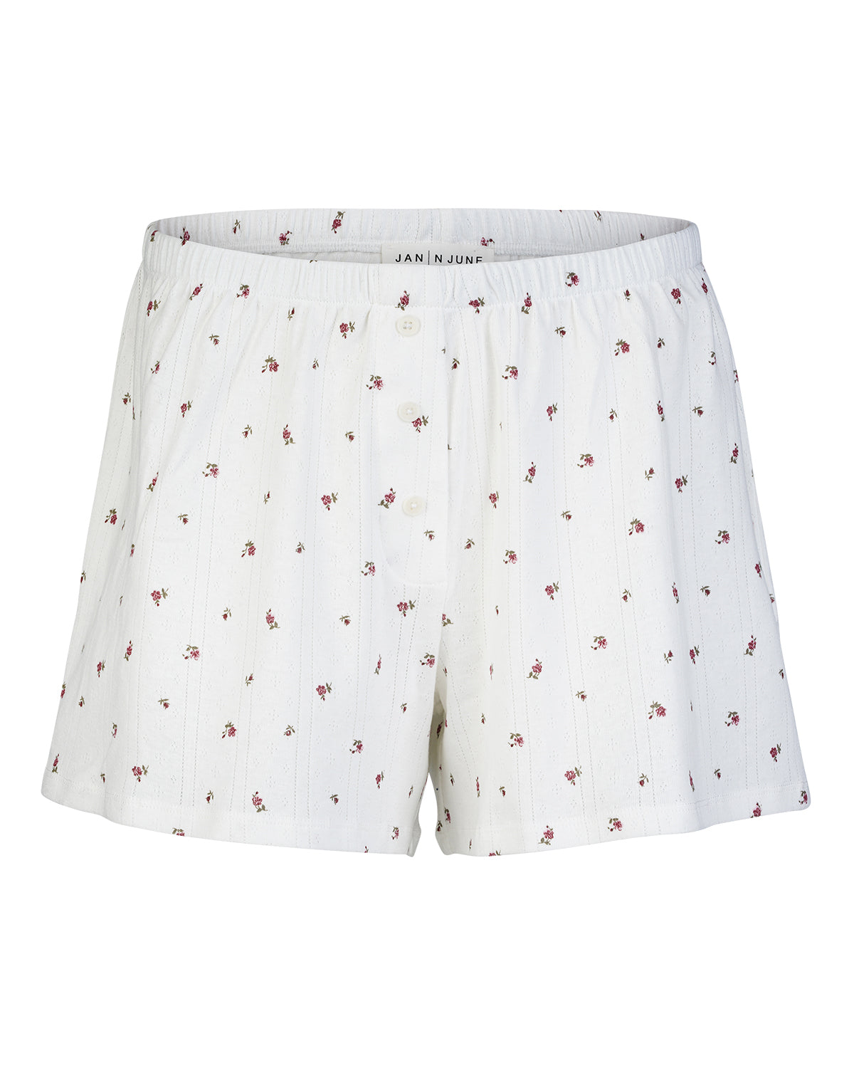 The POINTELLE PYJAMA SHORTS BLOOMY GOTS by jan-n-june are white cotton shorts featuring a pink floral print and thin stripes, made from GOTS certified organic cotton with an elastic waistband and central button fly for comfort.