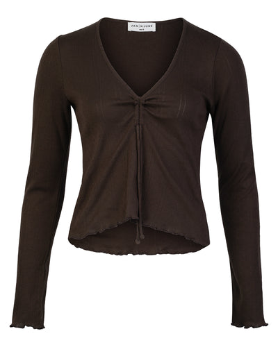 The POINTELLE PYJAMA V-NECK LONGSLEEVE CHOCOLATE GOTS by jan-n-june is a brown, ribbed knit top with long sleeves, a V-neckline, adjustable front tie, and ruffled hem and cuffs. Made from GOTS certified fabric.