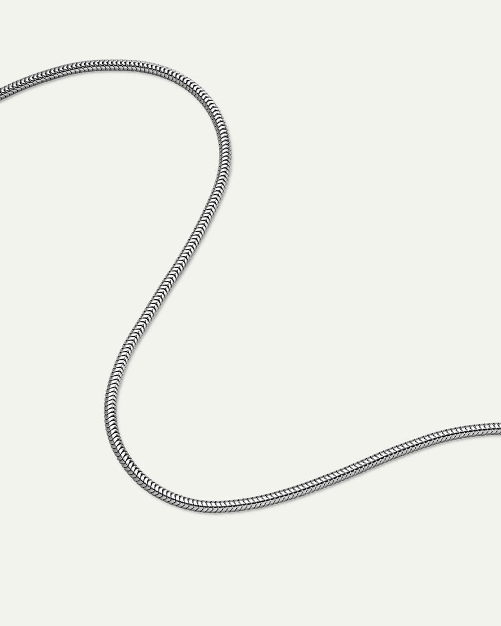 The DEAR DARLING BERLIN Delicate Short Snake Necklace Silver by jan-n-june, made from recycled 925 sterling silver, is displayed in a loose, curved S-shape on a plain white background.