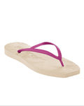 The SLEEPERS TAPERED FLIP FLOPS EGGNOG FUCSIA by jan-n-june features a single beige sandal with textured sole and fuchsia straps, crafted from biodegradable natural rubber, displayed on a white background.