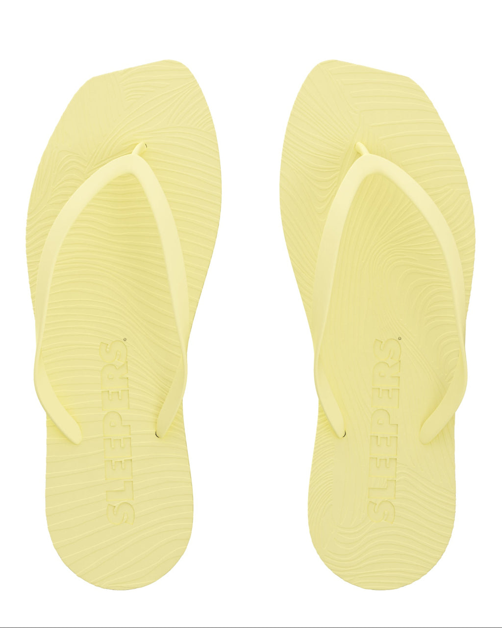 The jan-n-june SLEEPERS TAPERED FLIP FLOPS MELLOW YELLOW are pale yellow flip flops with textured soles and SLEEPERS embossed footbeds, made from biodegradable materials and shown on a white background.