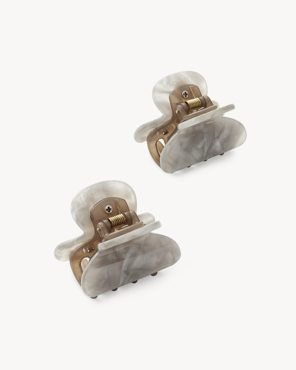 Two marbled light gray and beige MINI HEIRLOOM CLIP GREY SHELL hair clips by jan-n-june, crafted in Italy with metallic springs, shown on a white background—a chic and eco-friendly choice.