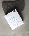 A white STEAMERY COLOR ABSORBER box by jan-n-june with turquoise and blue text sits on a dark stone surface. The packaging shows 40 sheets, small icons, instructions, and highlights effective discoloration prevention.